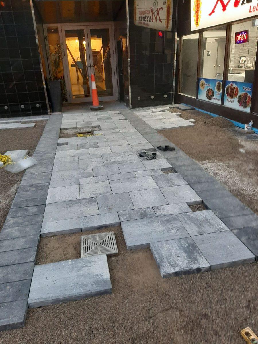 Paver entrance being laid in front of a storefront